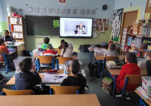Uczniowie oglądają prezentację na ekranie multimedialnym