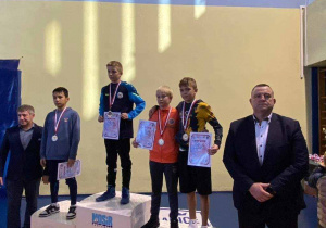 Zwycięzcy na podium a obok dorśli opiekunowie