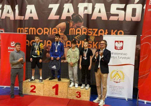 Zwycięzcy na podium a obok dorśli opiekunowie