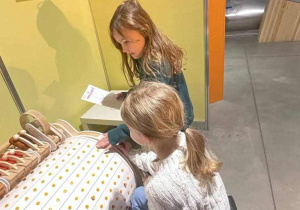 dziewczynki badają dotykiem przedmiot z wystawy w experymentarium