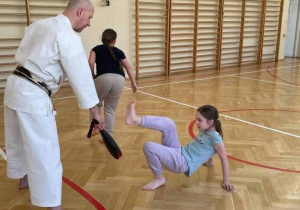 trener i uczeń wykonują ćwiczenie - siła kopnięcia w trenażer