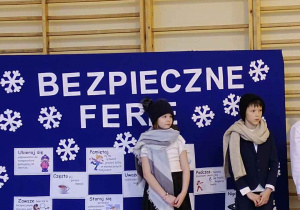 uczniowie na tle dekoracji dotyczącej bezpieczeństwa w zabawach zimowych