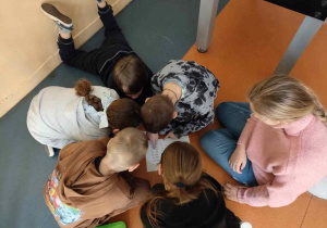 uczniowie pochyleni nad zadaniem