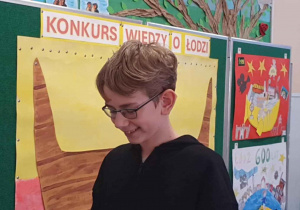 Uczeń a za nim godło Łodzi