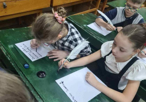 Uczennice próbują pisać gęsim piórem