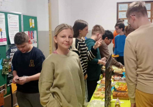 Uczniowie oglądają i sprzedają wystawione towary świąteczne