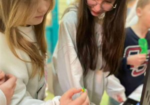 dziewczynki oglądają wystawoną w kiermaszu biżuterię