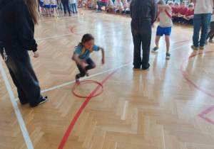 skoki przez leżace obręcze