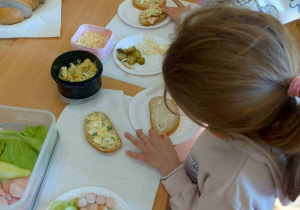 Dziweczynka przygotowuje zdrową kanapke