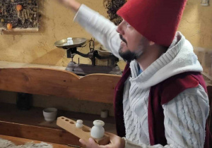 Skrzat pokazuje odważniki do wagi tradycyjnej szalkowej