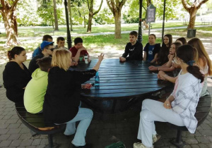 Lekcja na powietrzu - uczniowie i nauczycielki w altance przy stole