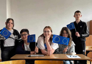 Organizatorka konkursu i uczestnicy - w dłoniach flagi UE
