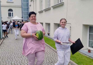 Mama i córka niosą smakołyki na stanowisko klasowe