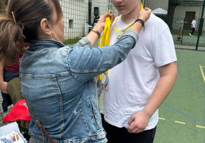 Dyrektor zawiesza medal na szyi ucznia