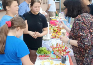 Uczennice częstują smakołykami nauczycielke