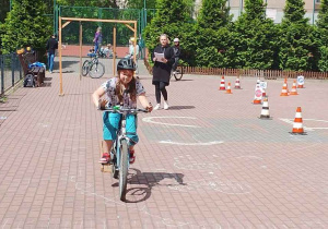 Uczeń pokonuje tor przeszkód podczas egzaminu na kartę rowerową