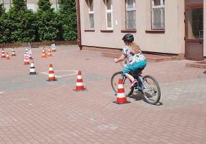 Uczeń pokonuje tor przeszkód podczas egzaminuna kartę rowerową