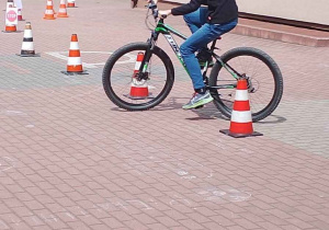 Uczeń pokonuje tor przeszkód podczas egzaminuna kartę rowerową