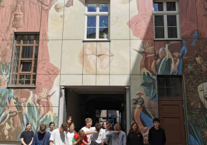 Uczniowie a za nimi ściana z innym muralen