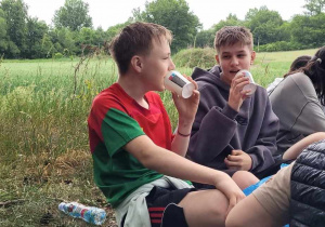 Chłopcy z kubkami od napoju w dłoniach