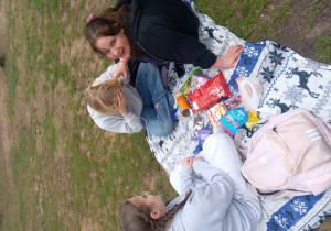 Piknik na kocyku - trzy uczennice pozują do fotografii