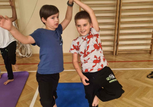 Chłopcy wykonują ćwiczenie na karimacie