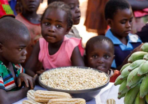 Czarnoskure dzieci przed miską z kukurydzą