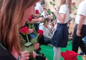 Zbliżenie na twarz p. Dyrektor, w dłoni róża