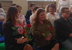 Dyrekcje siedzące w pierwszym rzędzie obdarowane kwiatami