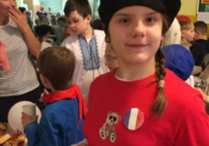 Uczennica ubrana w charakterystyczny strój z flagą Francji
