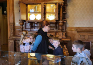 Oglądają eksponaty w gablotach