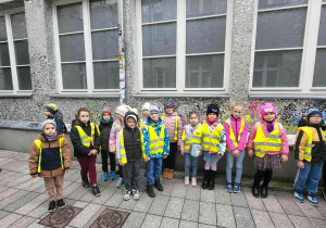 Uczniowie w kamizelkach odblaskowych w drodze do szkoły