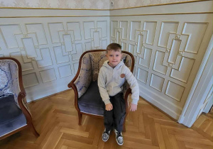 Uczeń siedzi w stylkowym fotelu