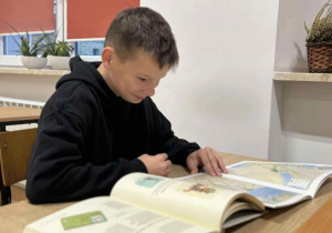 Uczeń nad rozłożonymi książkami