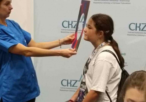 Osoba przymierza do twarzy dziewczyny szablon o owalnym otworze