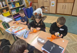 Uczniowie wykonują pracę plastyczną - przestrzenne dynie z pasków