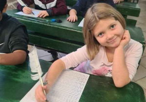 Uczniowie ćwiczą pisanie gęsim piórem