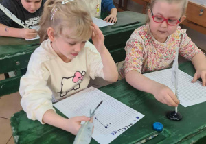 Uczniowie ćwiczą pisanie gęsim piórem