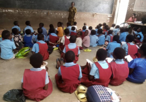 Młodsze dzieci siedzą na ziemi