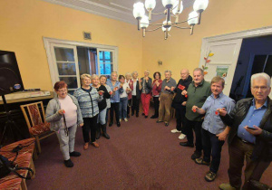 Obdarowani odblaskami Seniorzy pokazują otrzymany prezent