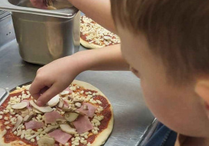 Uczeń przygotowuje swoją pizzę