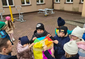 uczniowie na dziedzińcu szkoły chcą wypuścić w powietrze wykonany i napompowany powietrzem balon