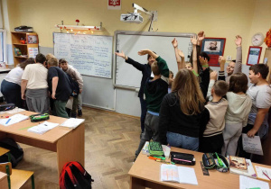 Grupy na tle gęsto zapisanej niebieskim pismem białej tablicy