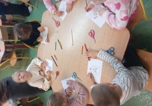 Dzieci kolorują sylwetkę misia