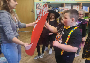 Zabawa w wybór imienia - przekłuwanie szpilką czerwonego serca z imionami wybranków