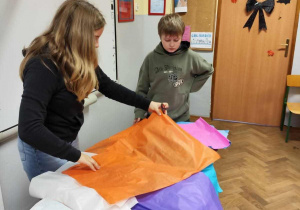 Uczniowie wybierają kolorową bibułę do ozdobienia krzesła