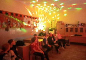 uczniowie a za nimi efekt świetlny podobny do roziskrzonego wybuchu