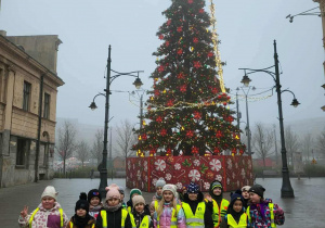 Uczniowie na tle choinki na Placu Wolności
