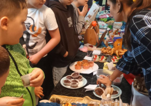 Uczniowie i wystawiony na stołach asortyment