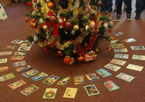 Uczniowie na tle choinki i kart świątecznych